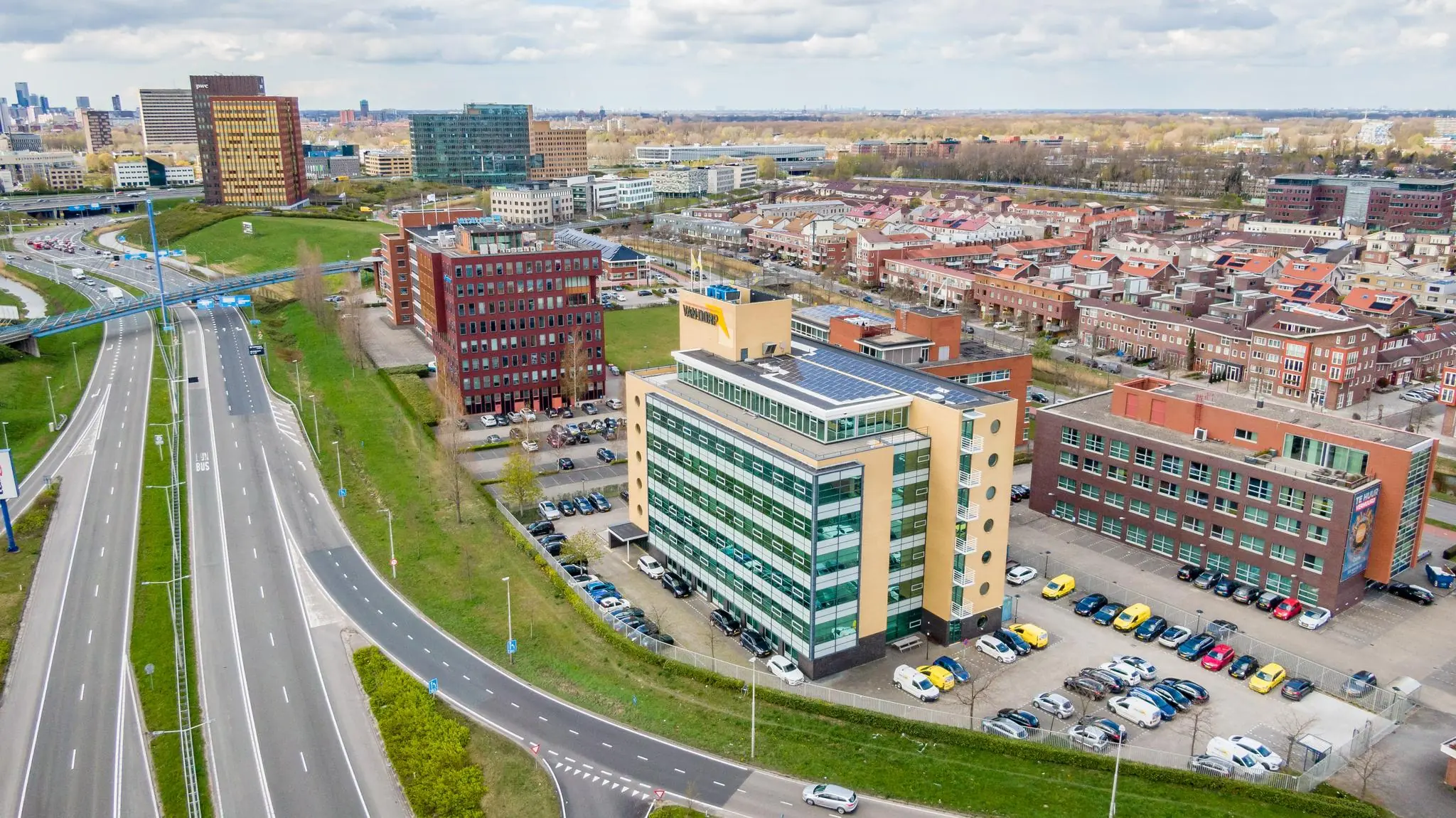 Luchtfoto van kantoren en woonwijken langs de Fascinatio Boulevard in Capelle aan den IJssel, met zicht op snelwegen en moderne gebouwen.